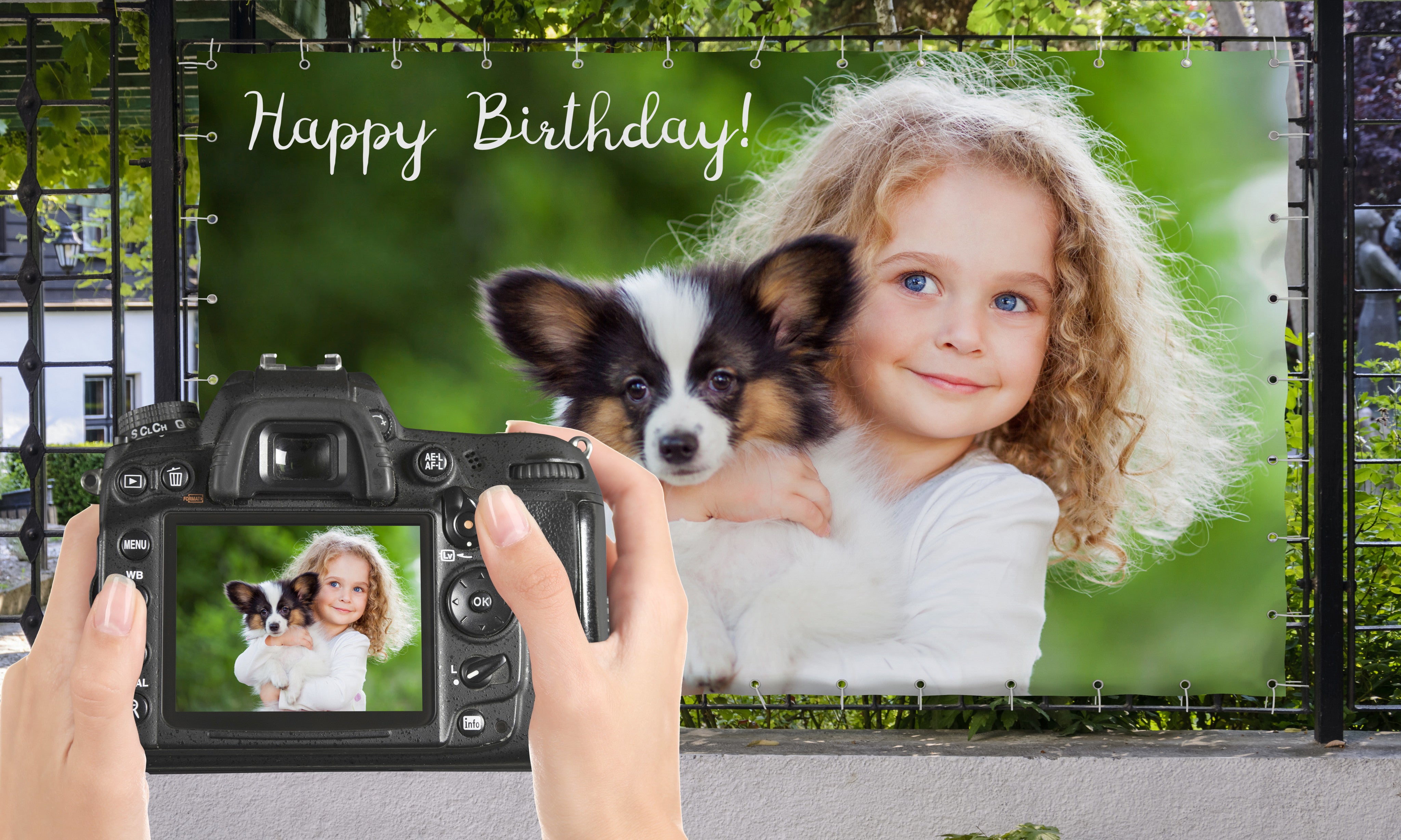 Banner mit einem Kind und Hund auf dem Arm am Zaun befestigt