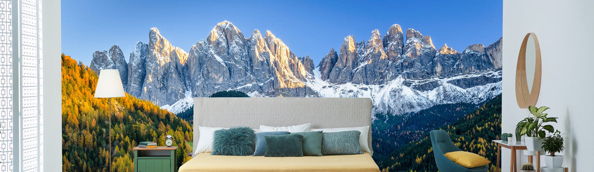 Bett und an der Wand dahinter eine Foto-Tapete mit Berschmotiv