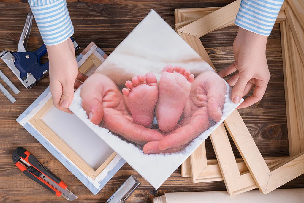 Leinwand mit Babyfüßen in der Hand der Mutter