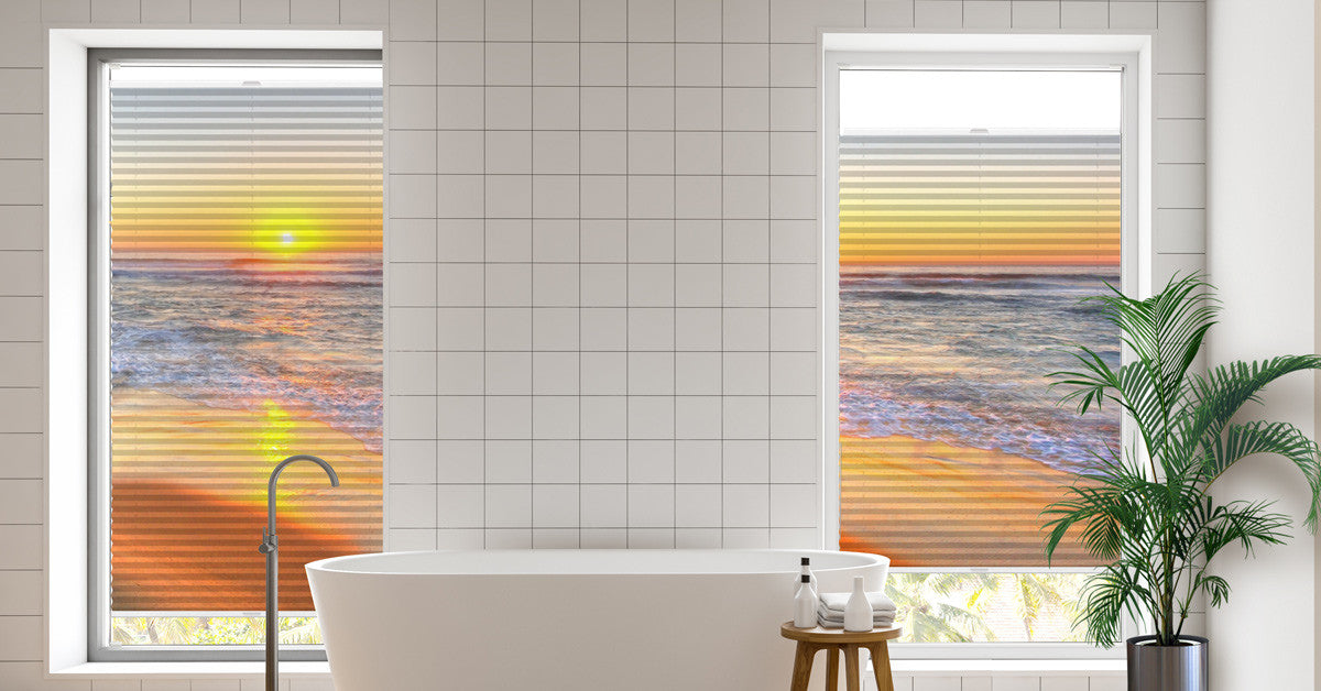 Badezimmer mit 2 Fenstern, daran jeweils ein Plissee mit Meer Sonnenaufgang
