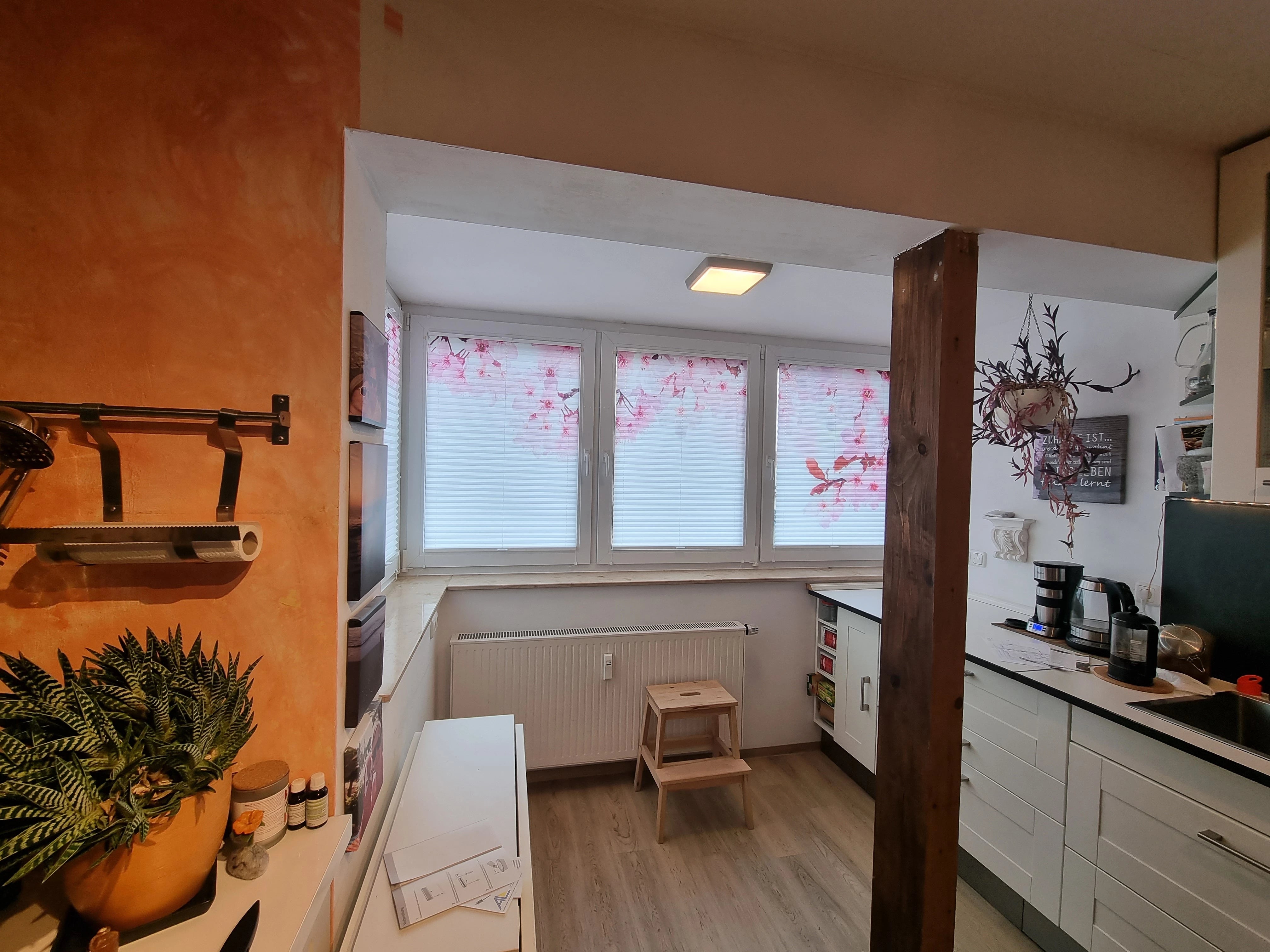 Beduckte Plissees mit Kirschblüten in der Küche am Fenster