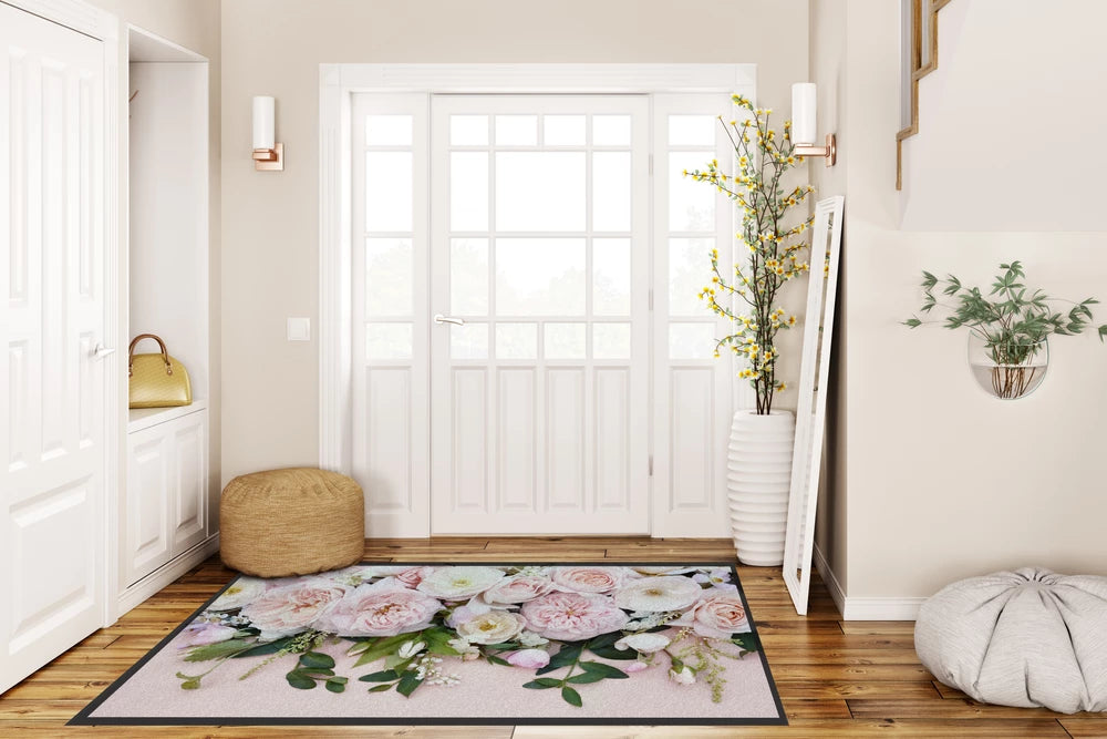 Große Schmutzfangmatte mit Blumenmuster hinter einer Eingangstür
