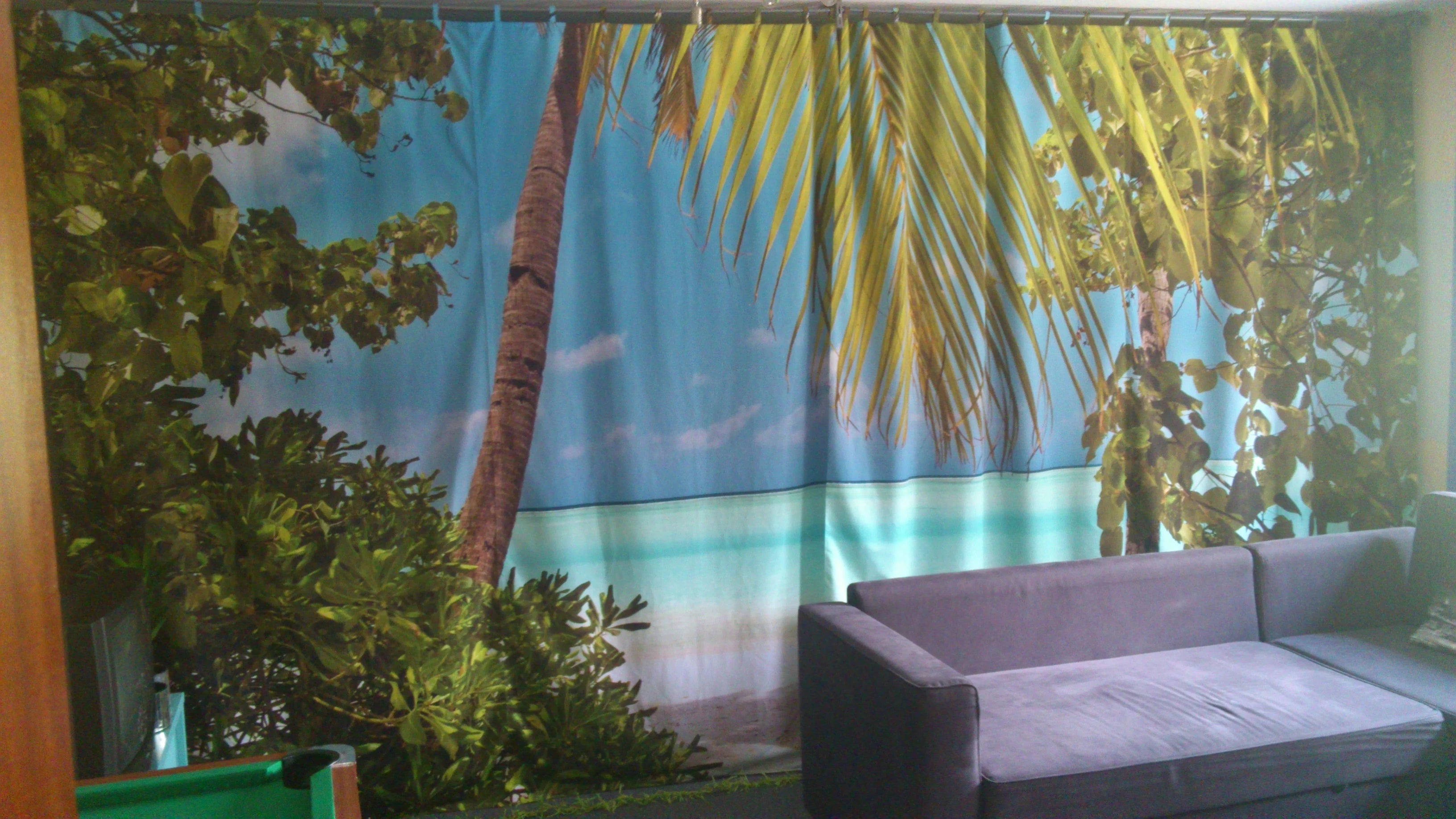 Fotovorhang mit Palmen am Strand bedruckt fungiert als Raumteiler 