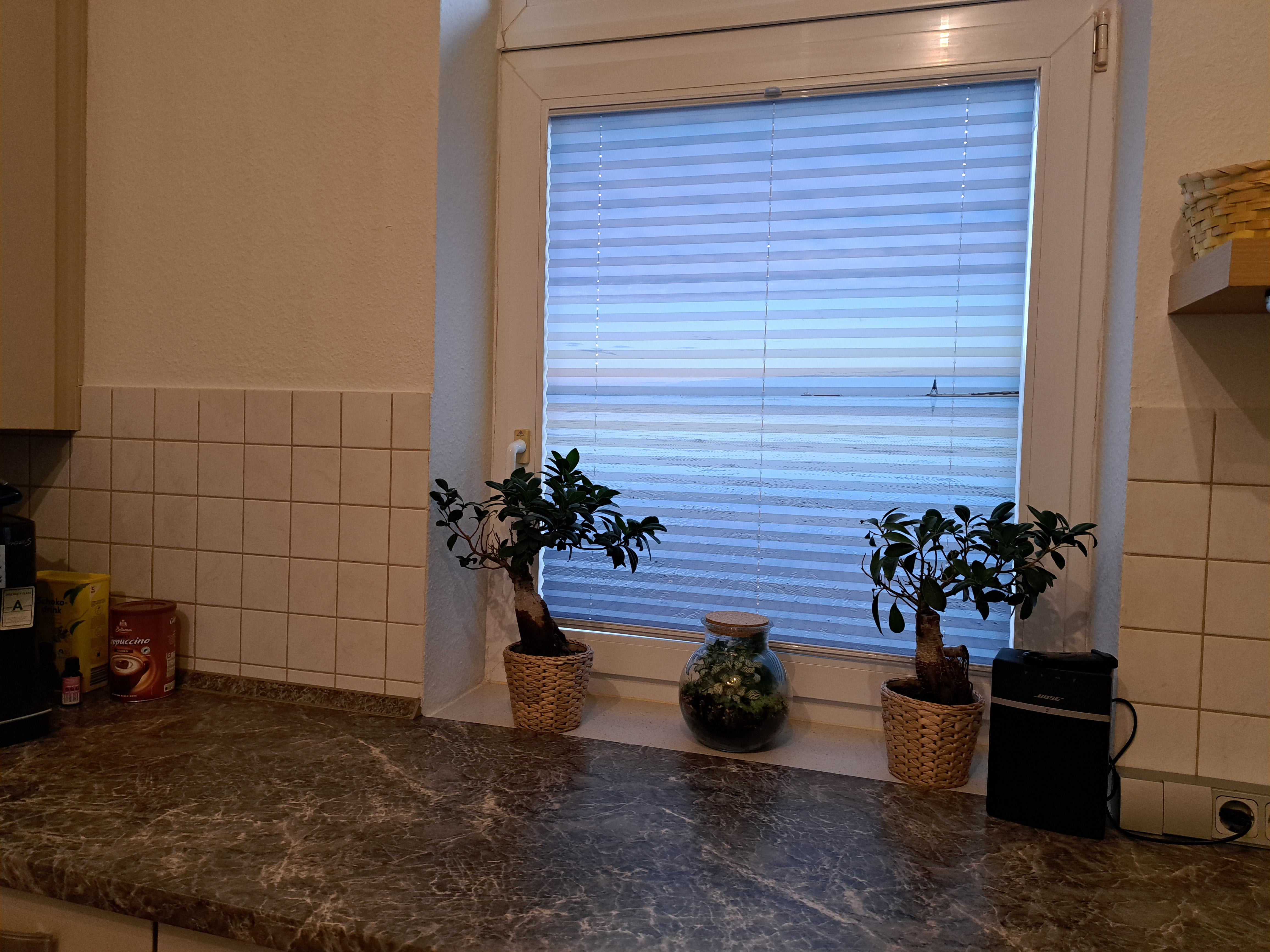 Urlaubsfoto auf Foto-Plissee gedruckt am Küchenfenster in die Glasfalz geschraubt mit Tageslicht hinterleuchtet
