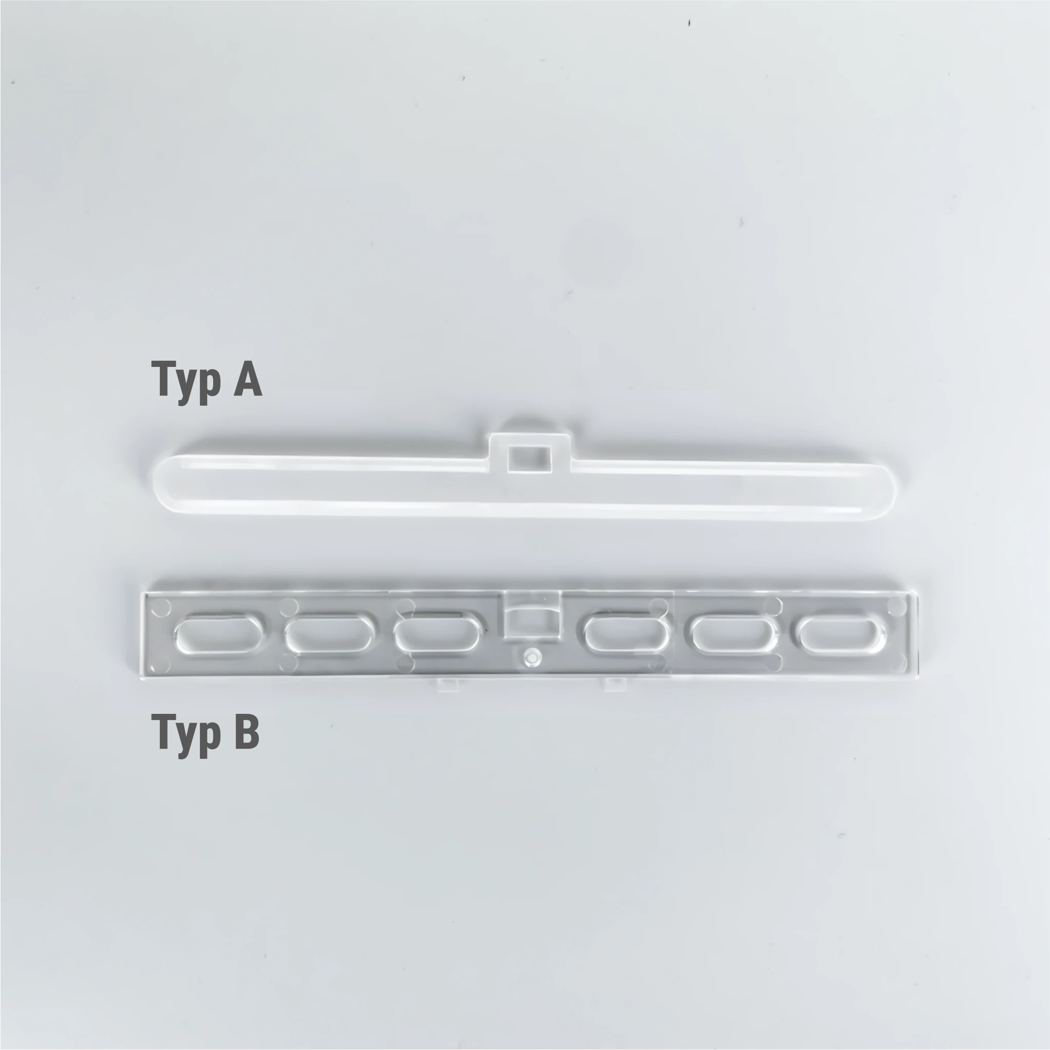 Lamellenzubehör – zwei transparente Kunststoffhalterungen (Typ A und Typ B) für die sichere Befestigung von Lamellenanlagen. Robustes Material für eine stabile Montage, kompatibel mit verschiedenen Lamellensystemen.