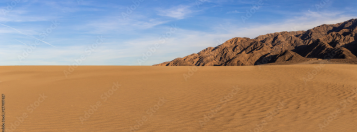Weite Sanddünen vor einer Bergkulisse