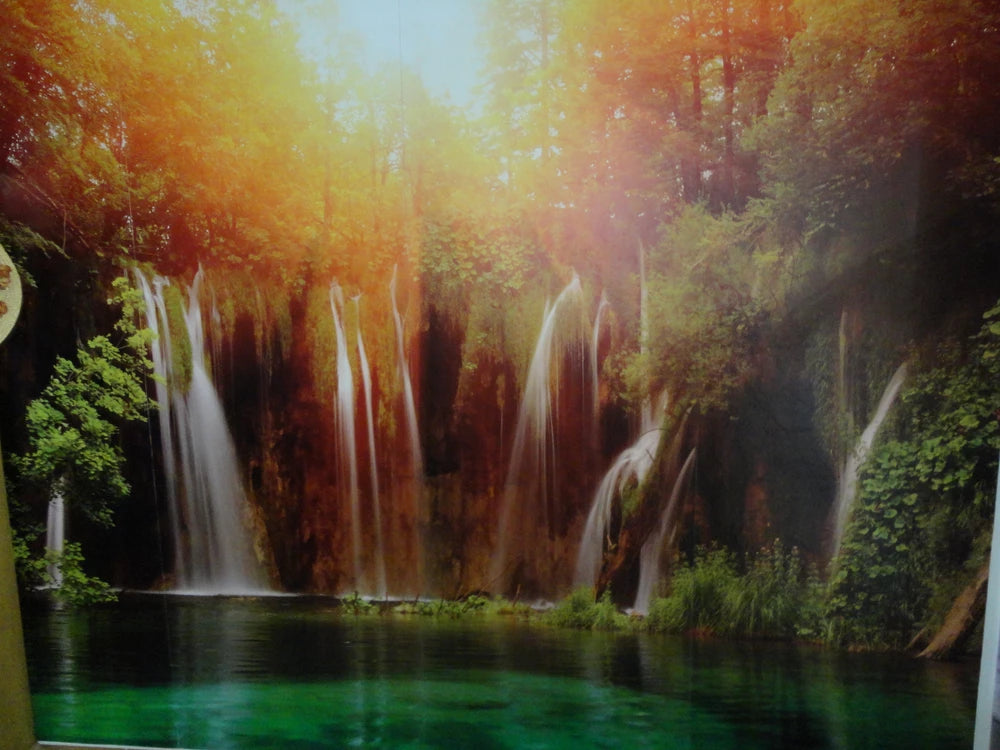 Wand mit einer Foto-Tapete bedruckt mit einem Wasserfall im Wald