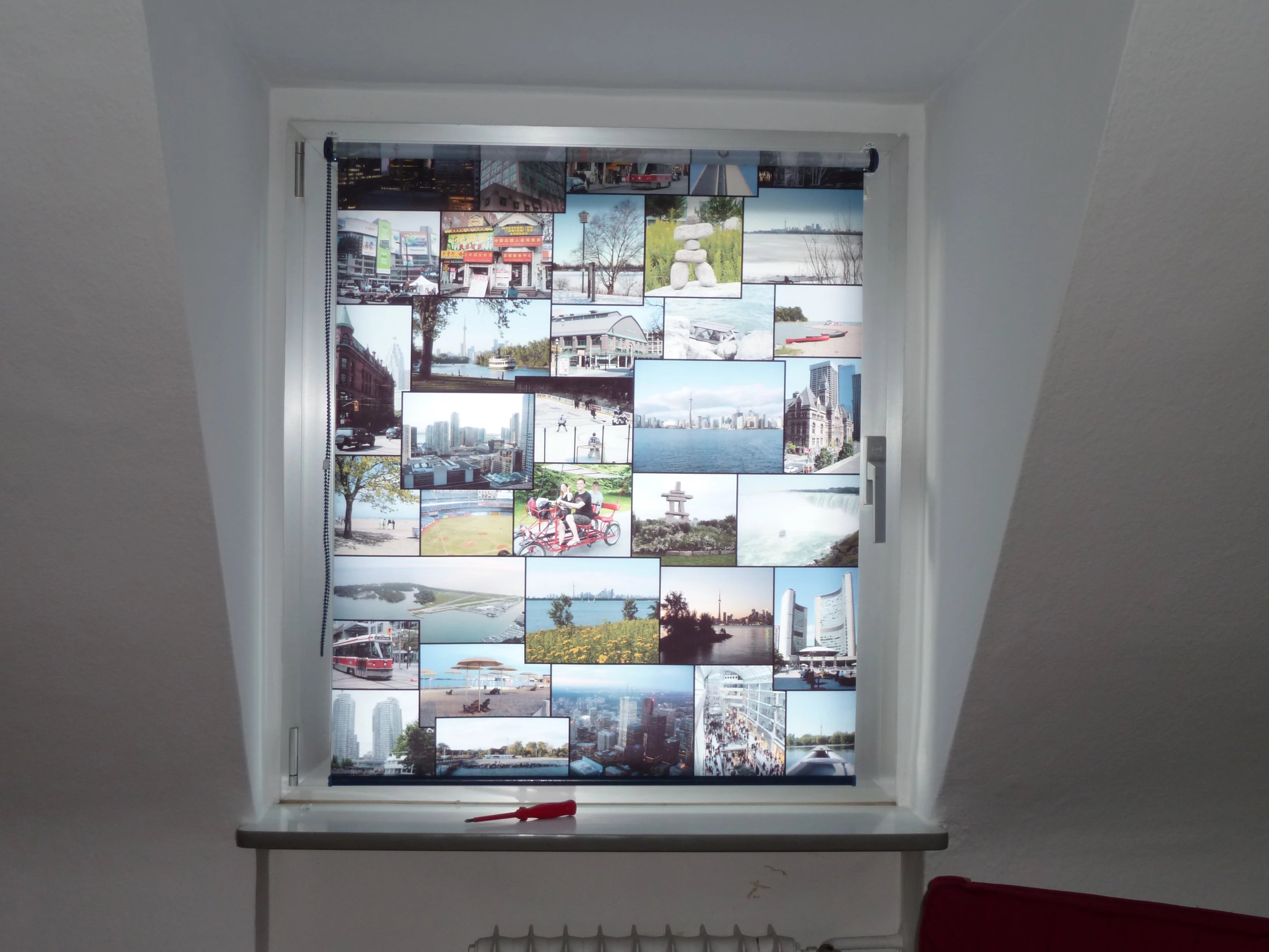 Bildcollage mit Urlaubsbildern selbst gestaltet auf Foto-Rollo am Fenster in der Gaube