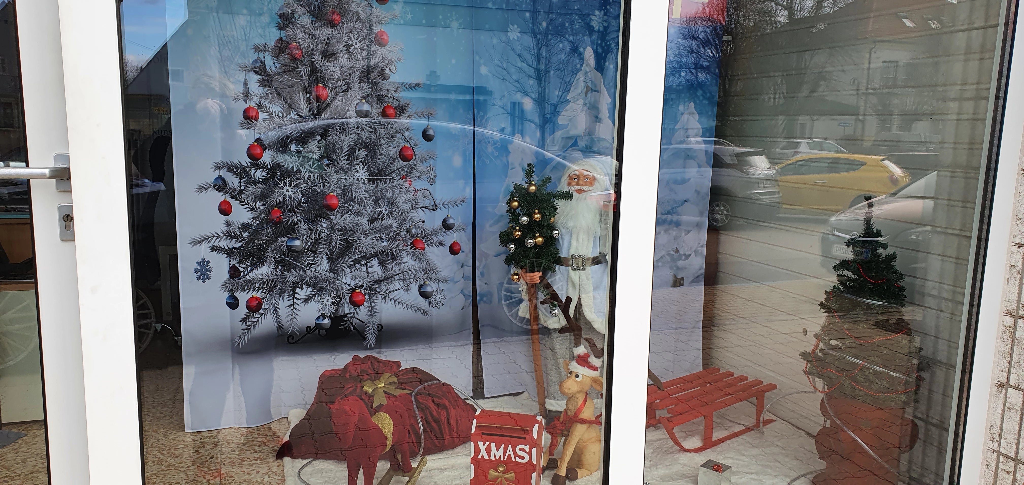 Schaufenster eines Ladengeschäfts weihnachtlich dekoriert mit Schiebevorhang mit Austauschpaneele bedruckt