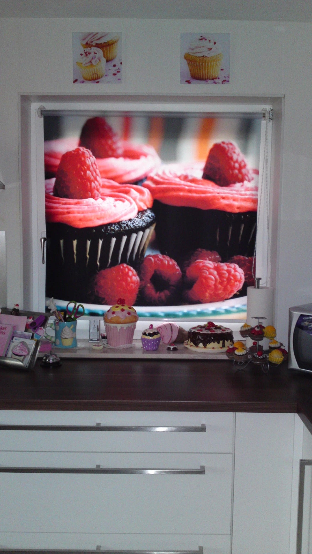 Ein Küchenfenster wird von einem bedruckten Foto-Rollo vor Blicken von außen geschützt. Das Motiv des Foto-Rollos zeigt Cupcakes mit Himbeeren