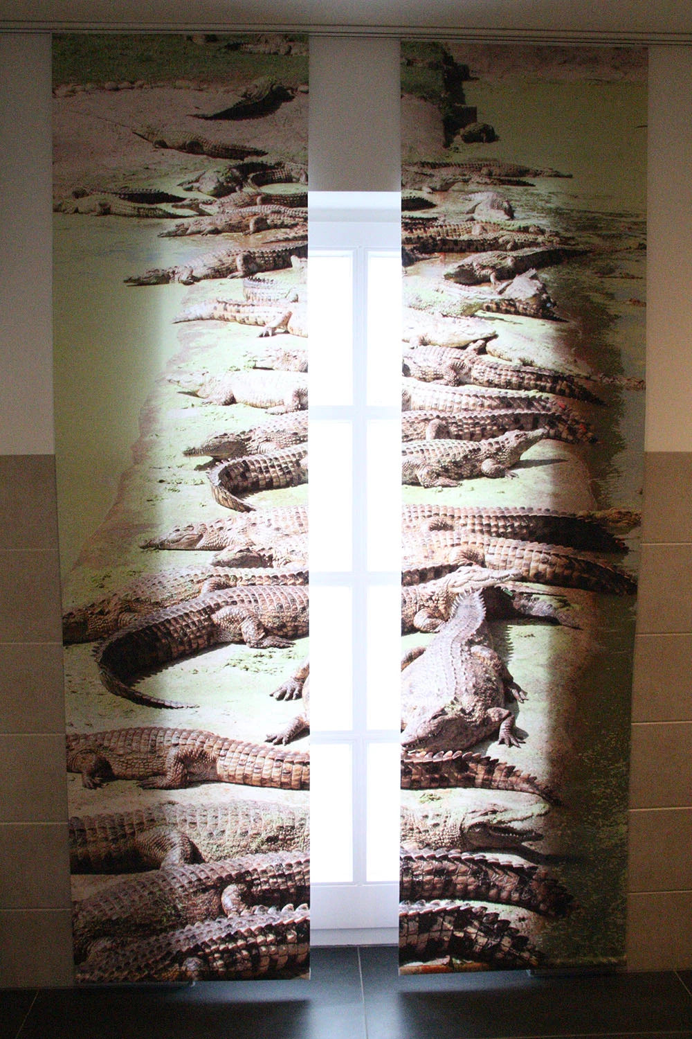 Badezimmerfenster mit Foto-Schiebegardine mit einer Reihe von Krokodilen bedruckt mit leicht geöffneten Paneelen