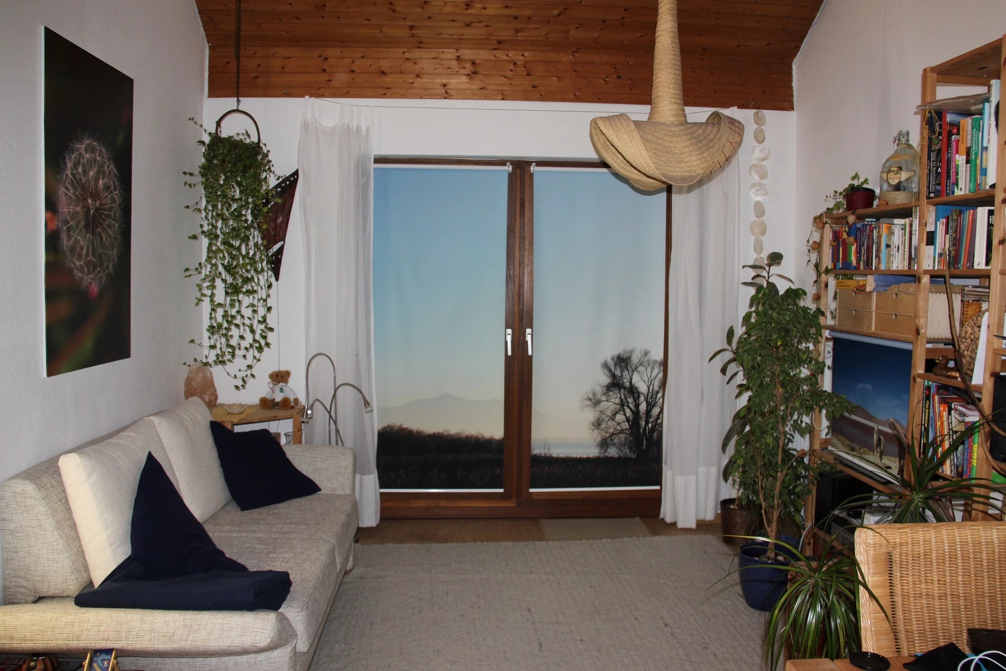 eigenes Urlaubsmotiv gedruckt auf Fotorollo zweiteilig vom Chiemsee im Wohnzimmer an der Terrassentür. Links an der Wand hängt eine Leinwand mit selbst gewählten Motiv