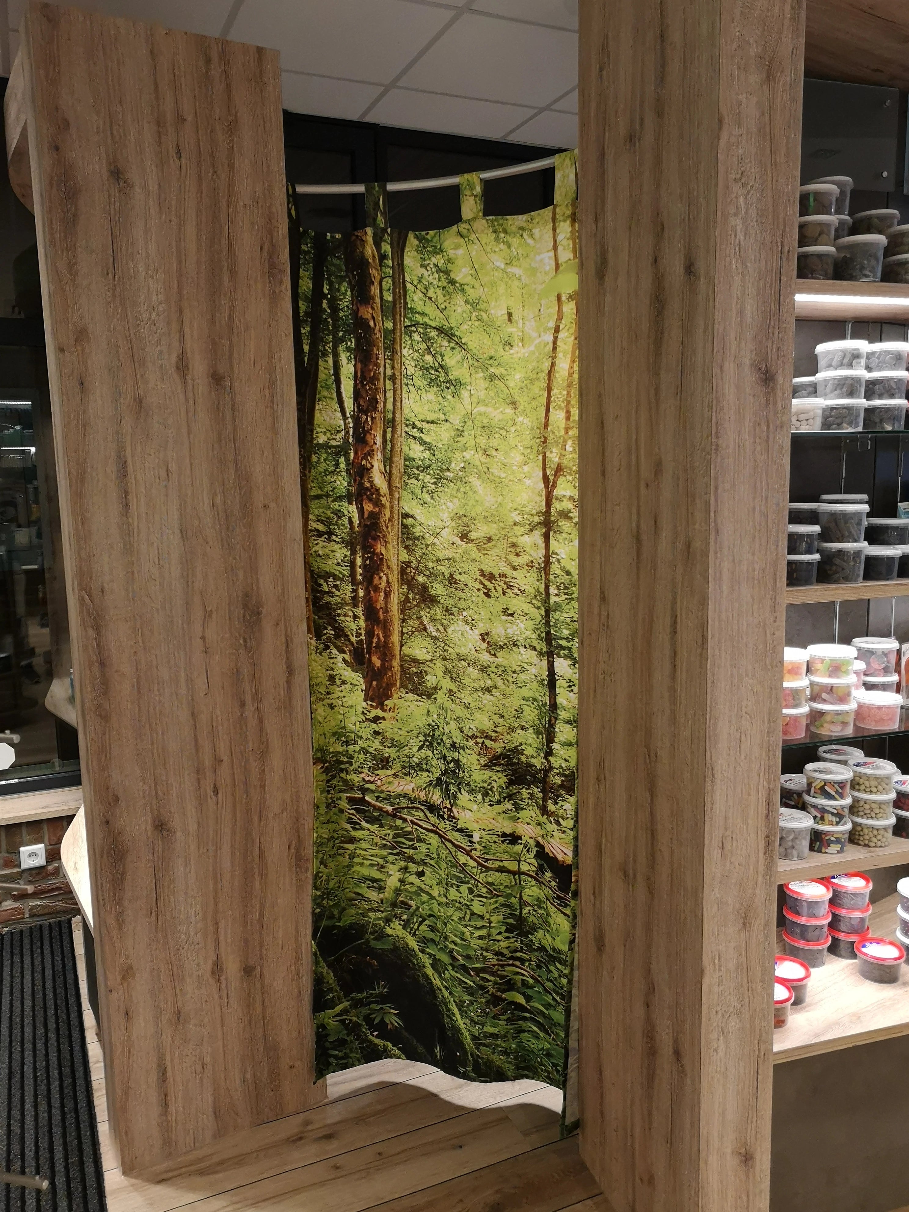 Bedruckter Foto-Vorhang als Raumteiler mit Waldmotiv bedruckt in der Apotheke um den Mitarbeiterbereich vom Kundenraum abzutrennen
