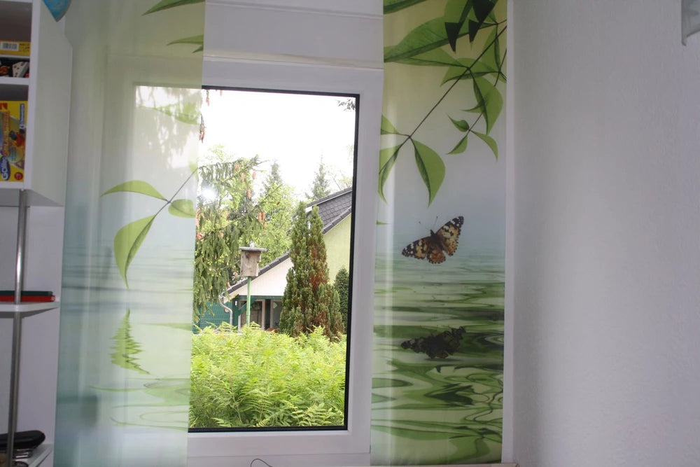 Zweiteilige Schiebegardine an einem Fenster mit Motiv Schmetterling und Bambusblätter