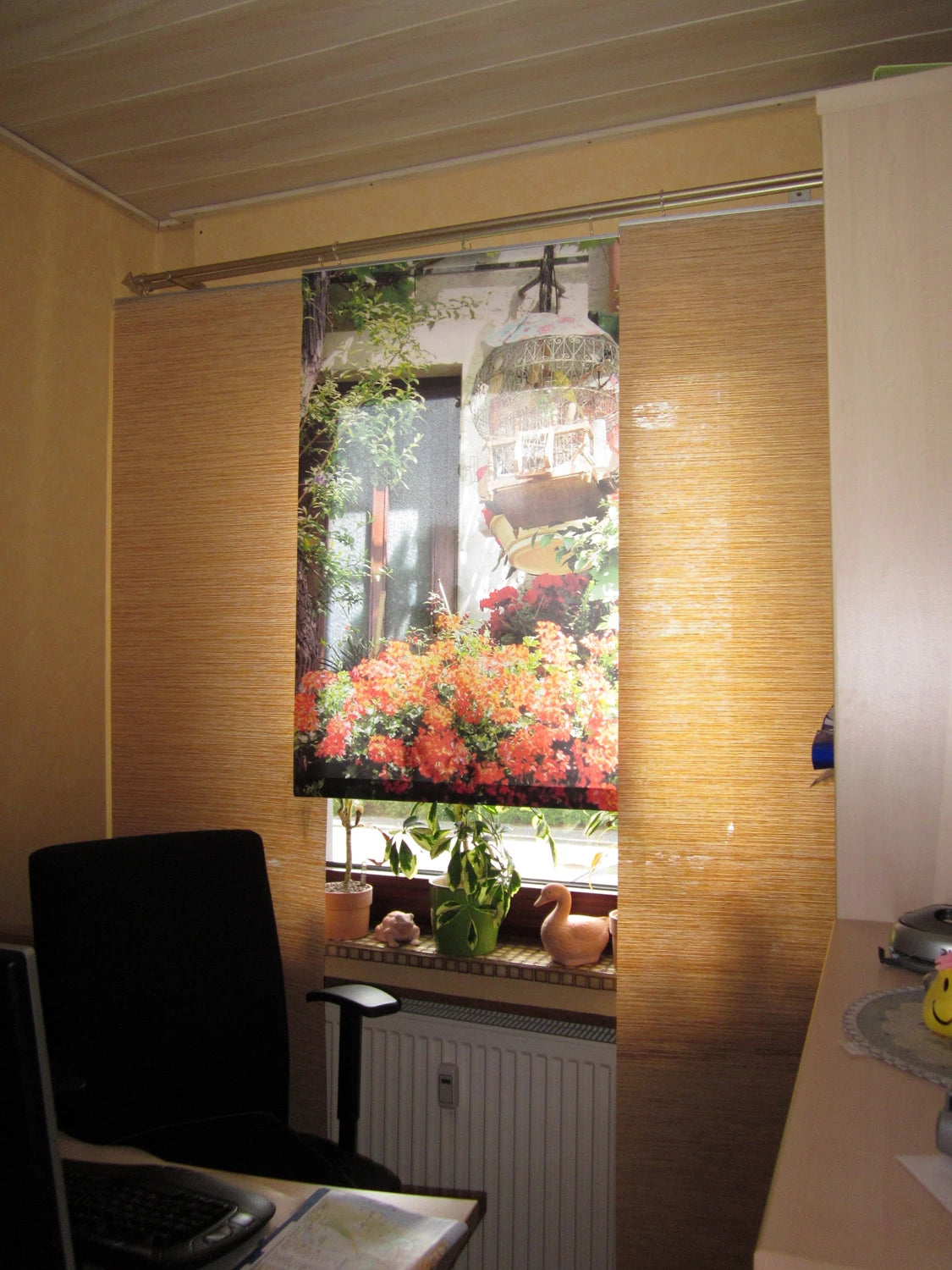 eine Bambus-Paneele vom Schiebevorhang wurde durch eine bedruckte Paneele mit floralen Motiv ersetzt im Büro