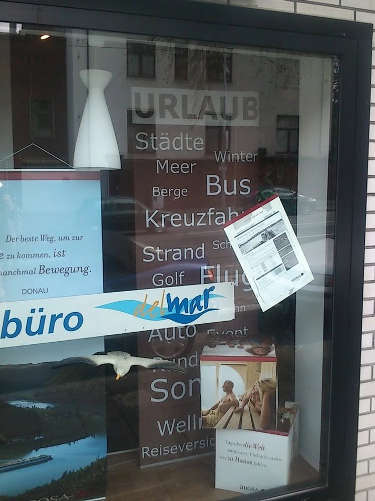 ein Reisebüro verwendet eine Schiebegardine mit Werbung bedruckt im Schaufenster 